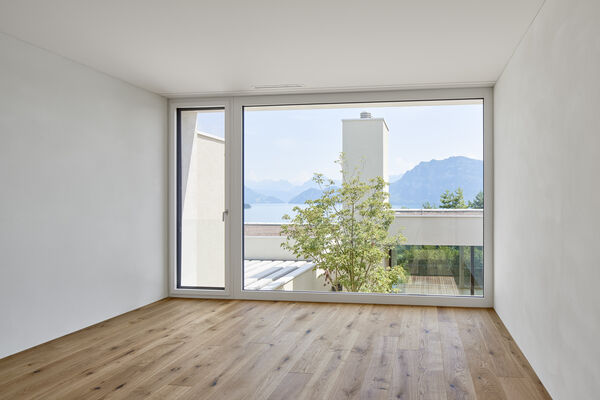 Blick auf einem Zimmer der Patiohäuser Naumatt über den Patio und das Wohnzimmer hinweg auf den Vierwaldstättersee